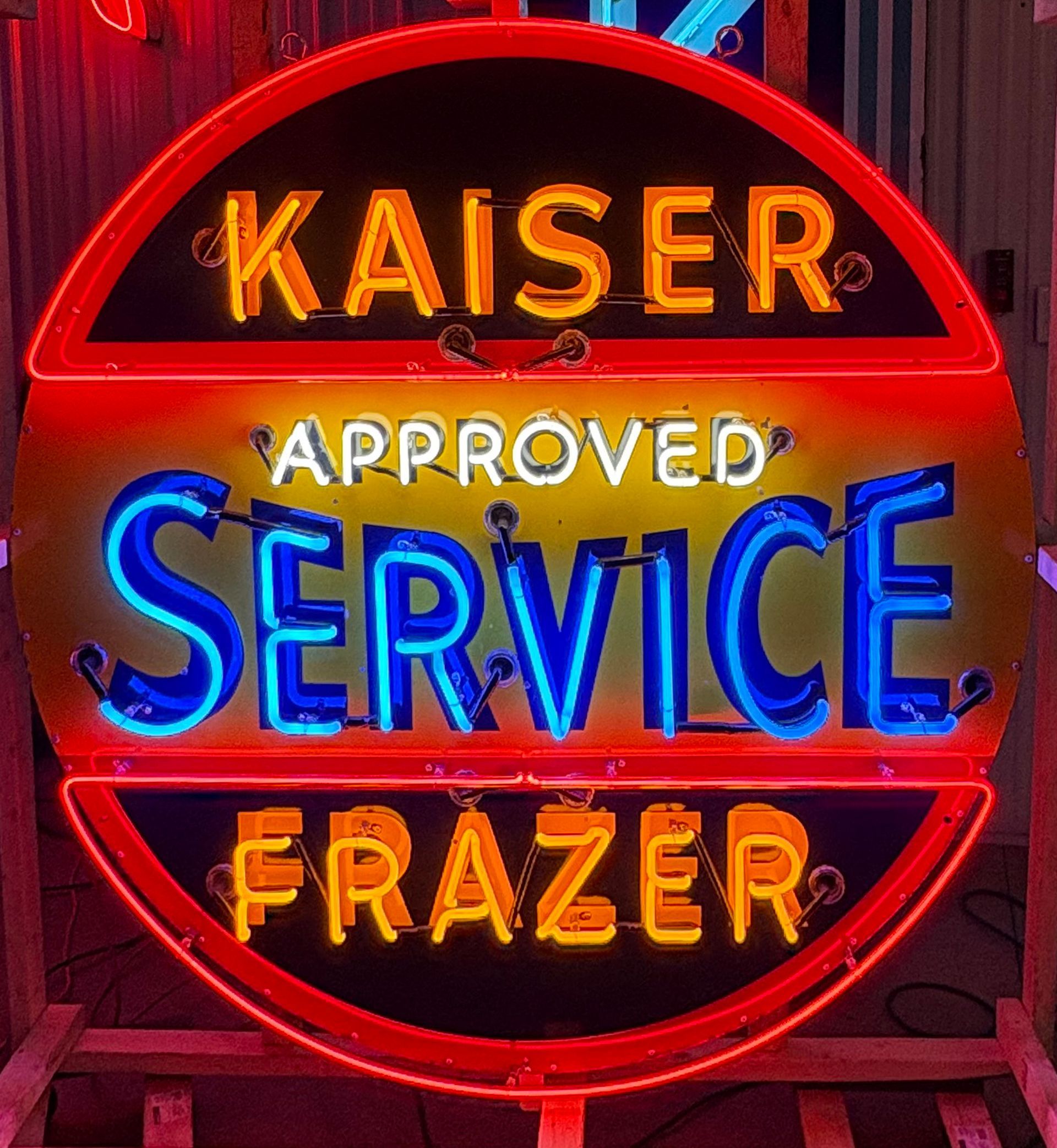 Neon sign for Kaiser Frazer Service, red, black, blue, and yellow.