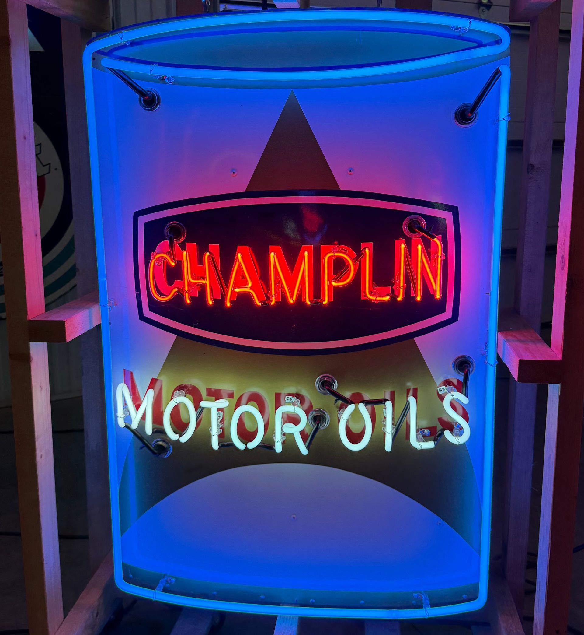 Neon sign reading “Champlin Motor Oils” in red, white, and blue