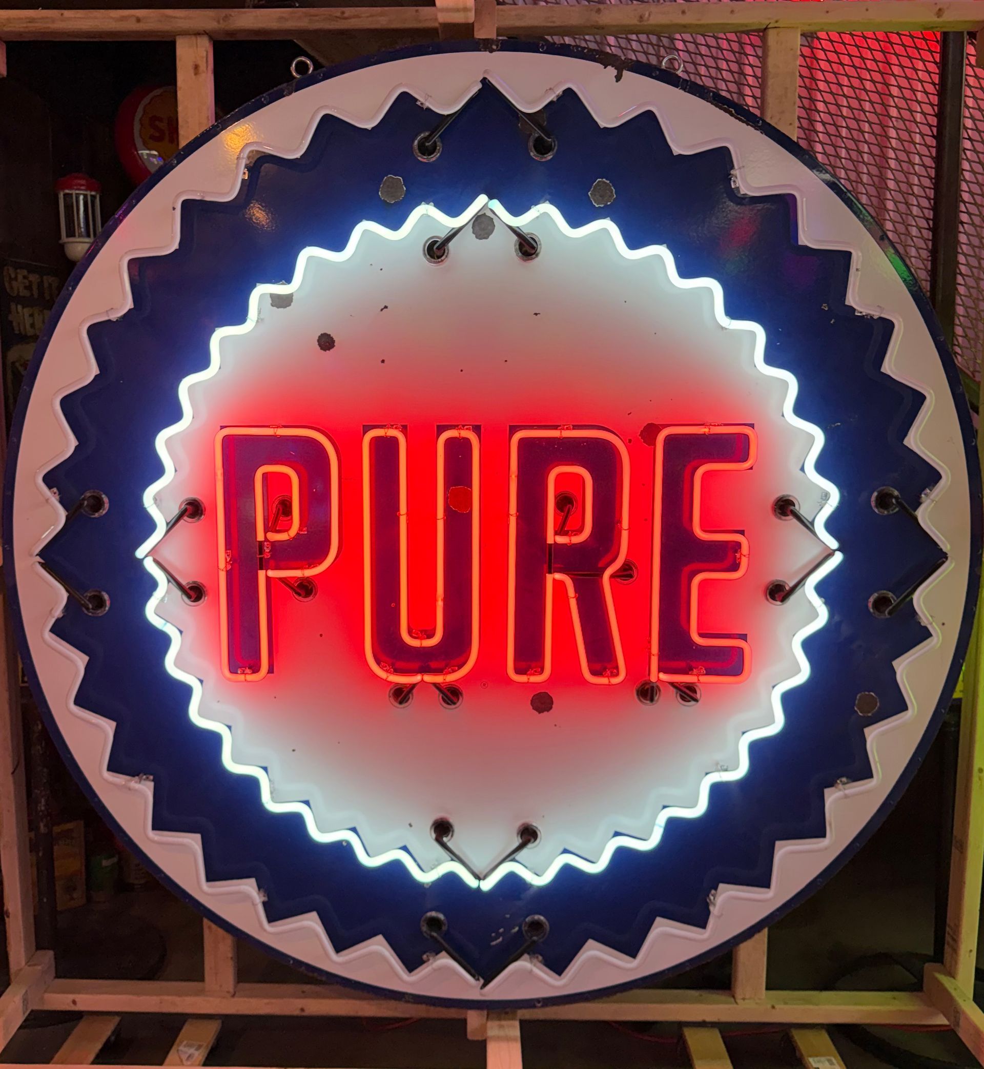 Neon sign reading “PURE” in red inside a glowing blue scalloped circle