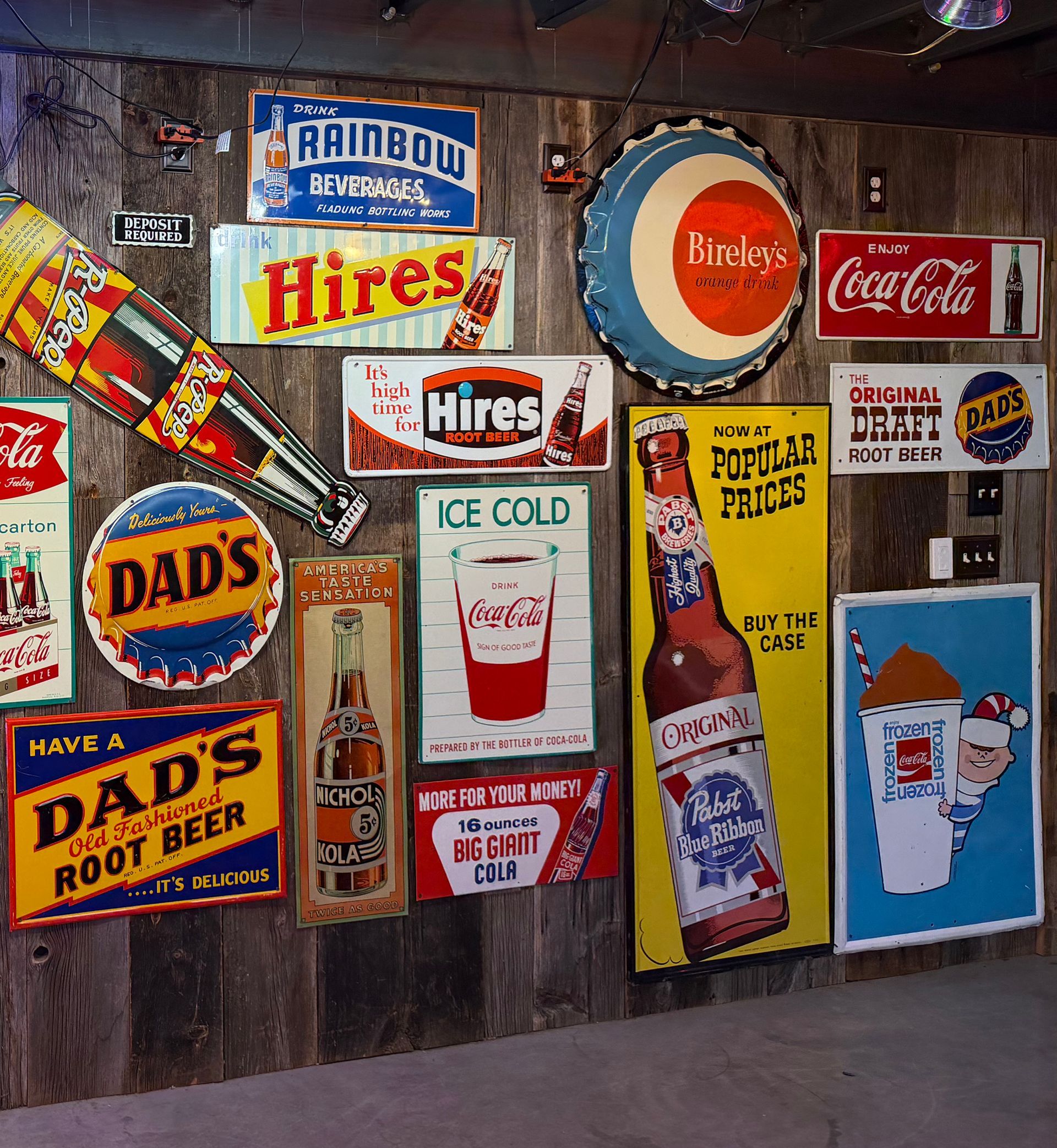 Wall covered with old, original advertising beer, soda, and root beer signs