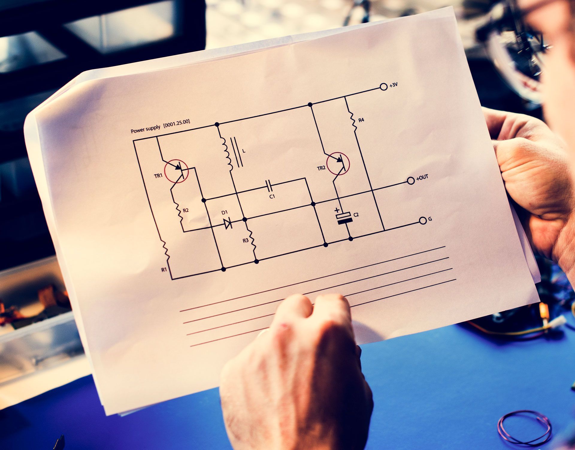 Person holding and examining a circuit diagram.