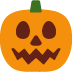 A pumpkin with a face on it and a green stem.