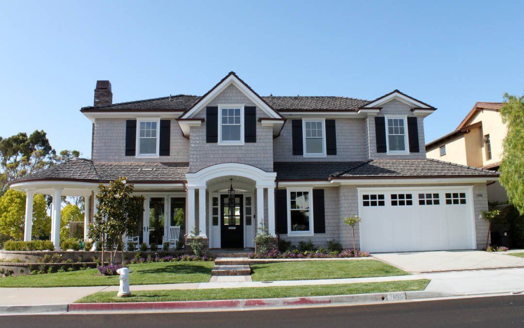 A large house with a white garage door and black shutters