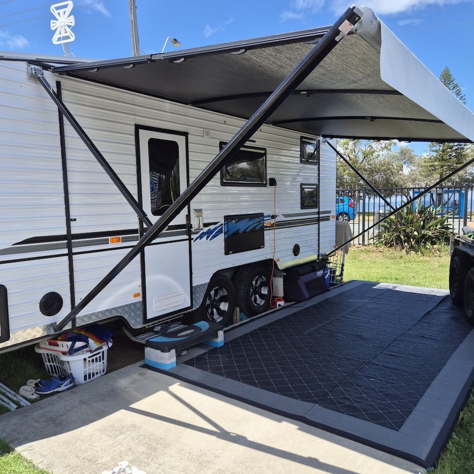 White camper trailer with awning extended, parked on concrete pad— Revive Caravan Repairs in Kippa-Ring, QLD