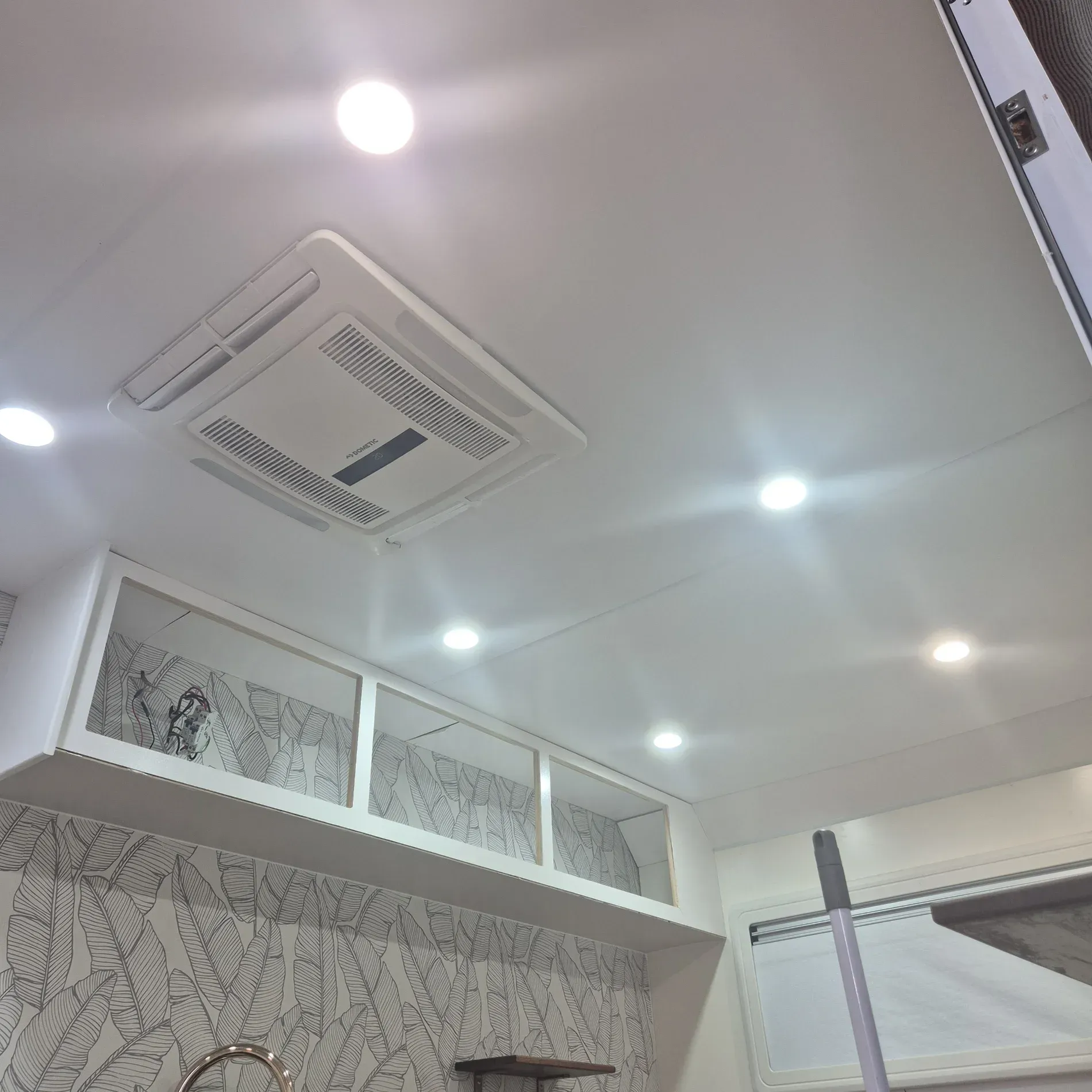White ceiling with recessed lighting, an air conditioner, and built-in white cabinets — Revive Caravan Repairs in Kippa-Ring, QLD