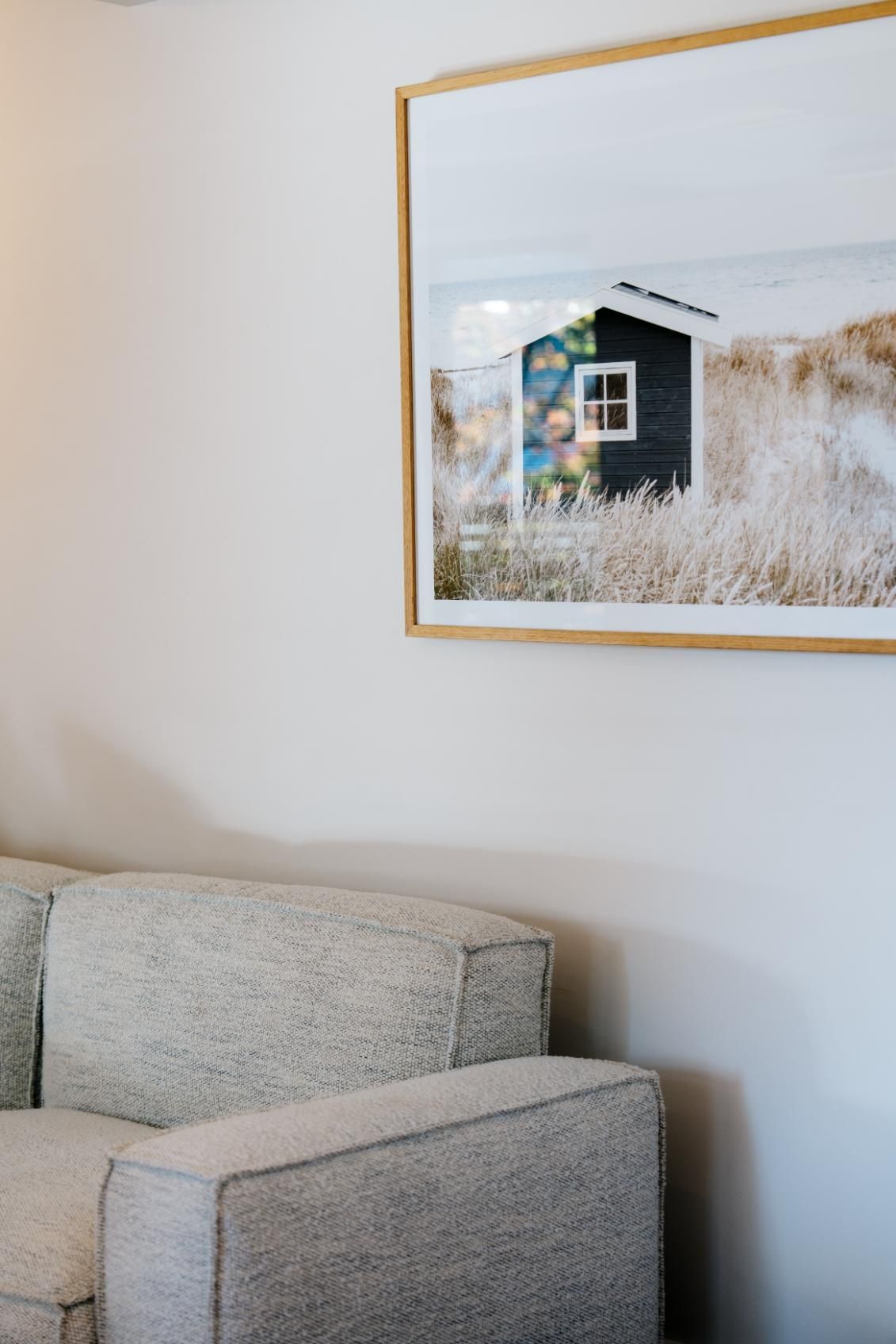 A Living Room With a Couch and a Picture on the Wall Above It — Hyde Burchell Buyers Agents In Canberra, ACT