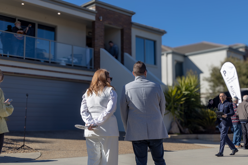 People Standing Outside a Modern House with A Balcony — Hyde Burchell Buyers Agents In Canberra, ACT