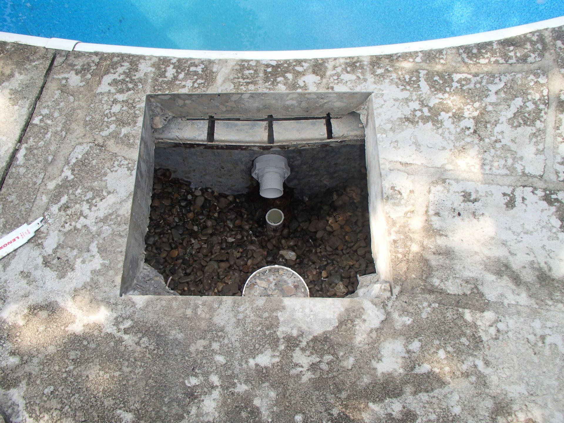A hole in the ground next to a swimming pool