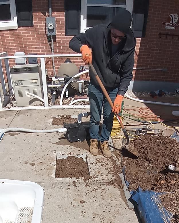 A man is digging a hole in the ground with a shovel