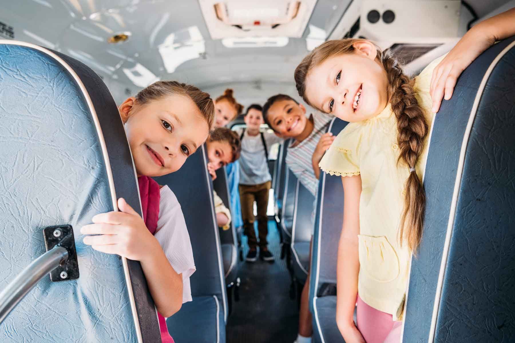 A group of children are riding on a school bus.