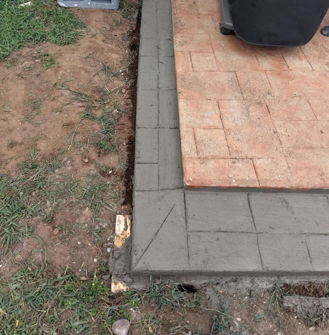 a person is using a trowel to spread cement on a wall
