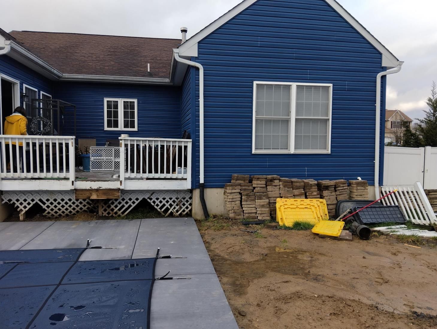 a man is using a green and black drill on a siding of a house