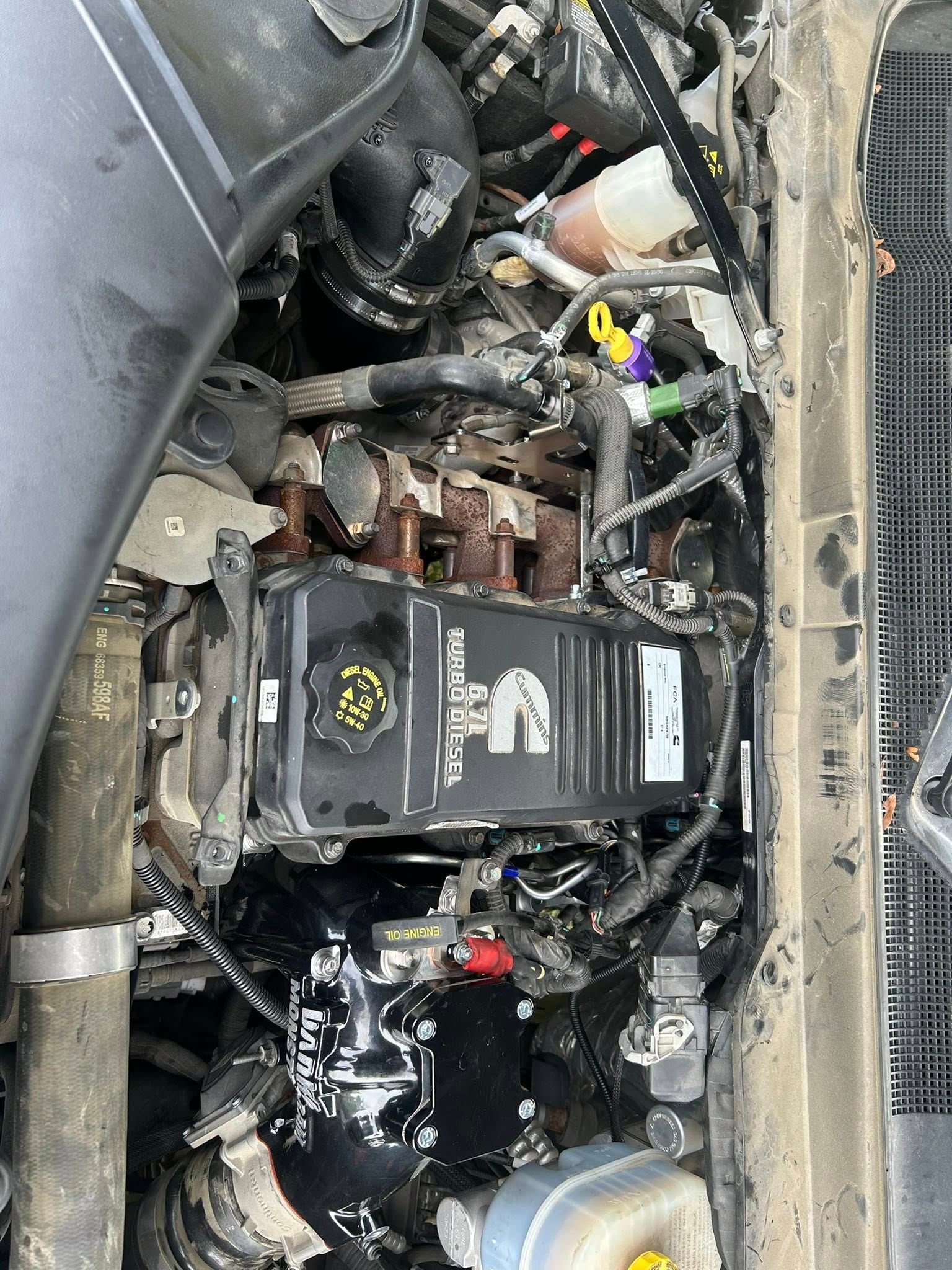 Severely burned car engine bay with melted parts and exposed battery components