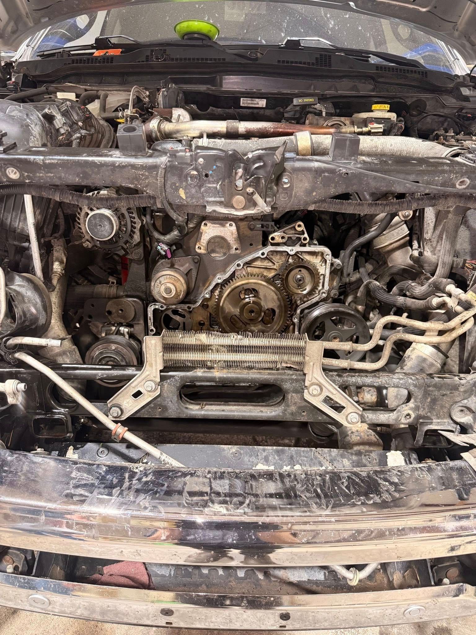 Burned-out car front with exposed engine and charred, damaged bumper