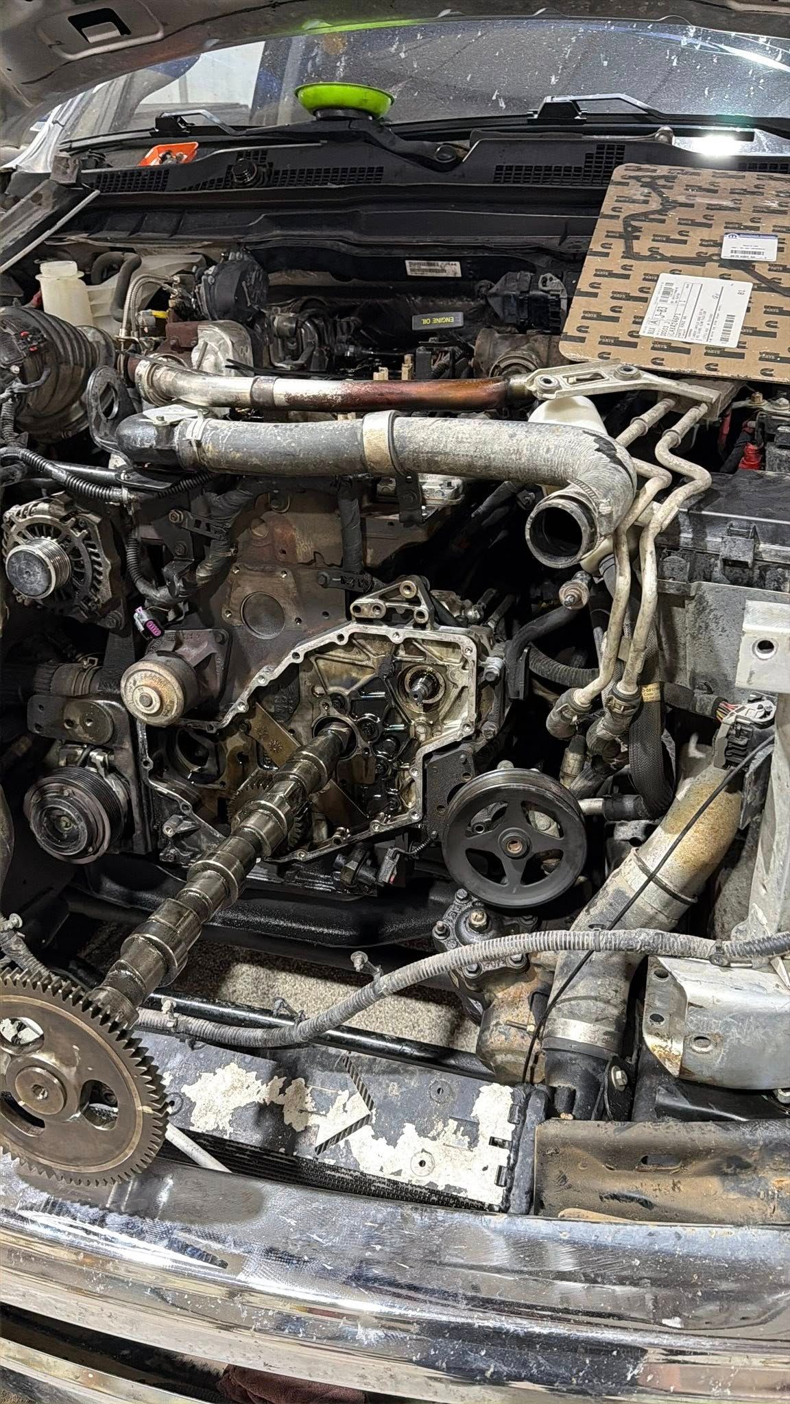 Car engine bay with severe fire or collision damage, exposed mechanical parts and melted components