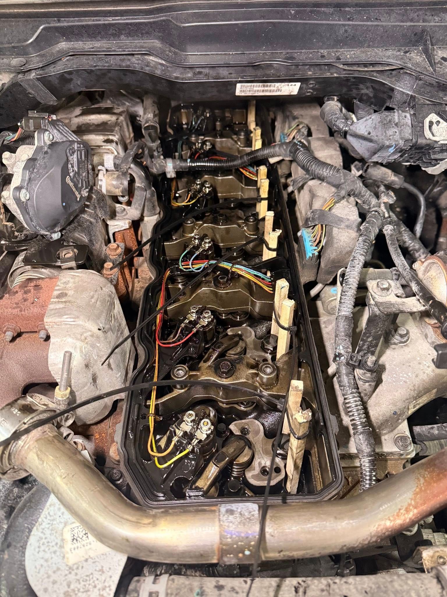 Engine bay with a damaged engine, exposed wiring, and a silver pipe in the foreground