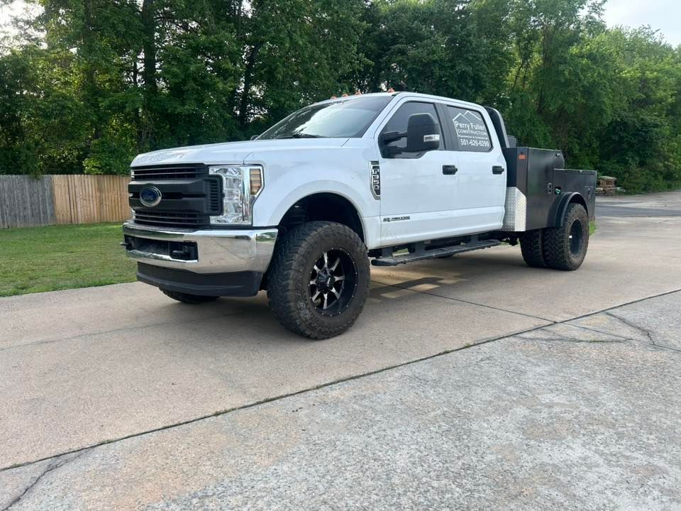White pickup truck with black wheels and an open flatbed parked on a driveway