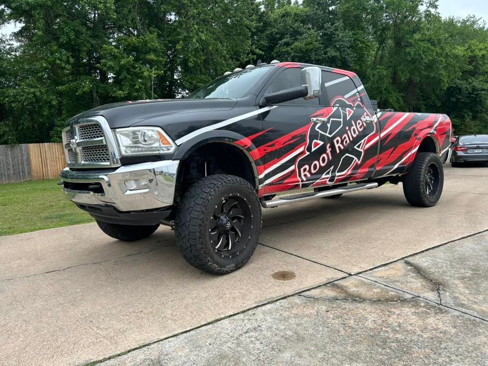 Black lifted pickup truck with red graphics parked on a driveway