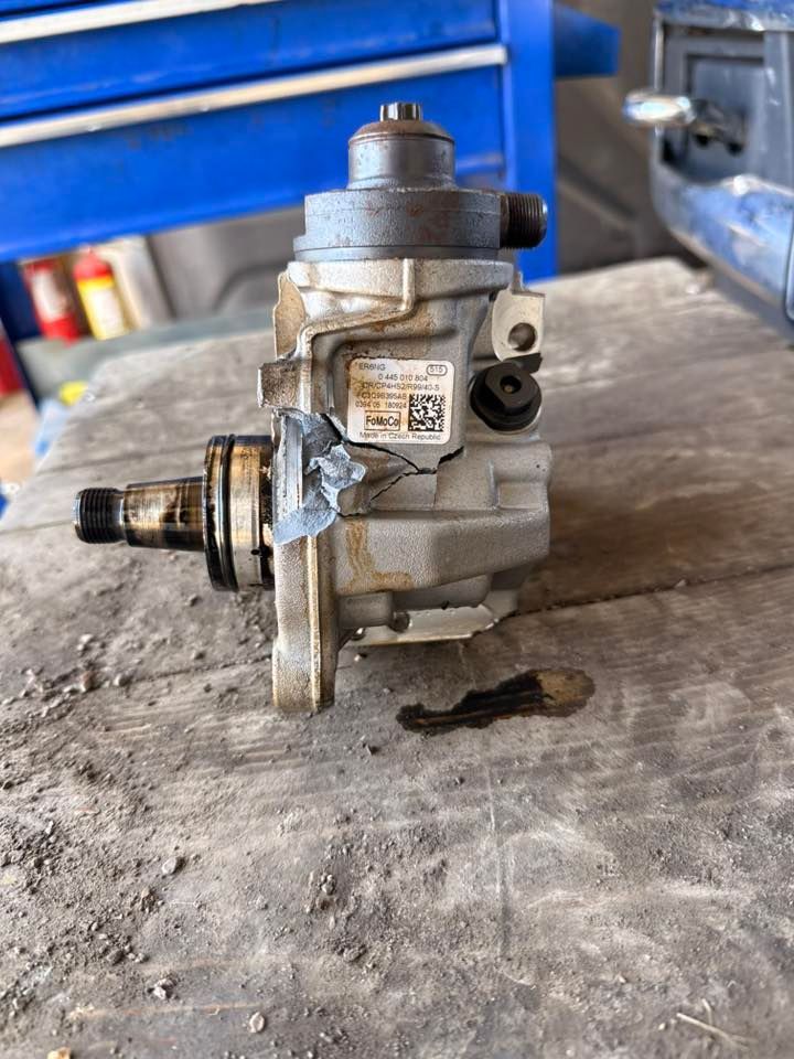 Close-up of a used metal mechanical pump or valve assembly on a workbench.