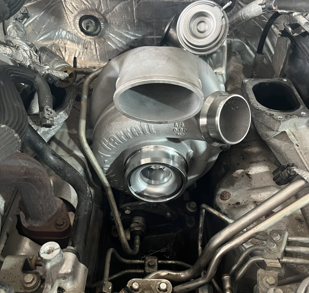 Close-up of a car engine bay with a large turbocharger and exposed metal piping