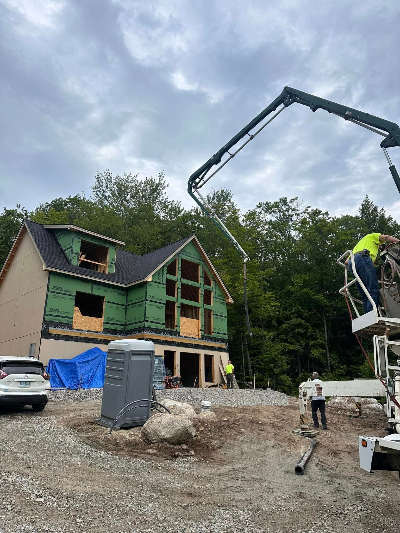 A construction site with a house under construction and a crane.