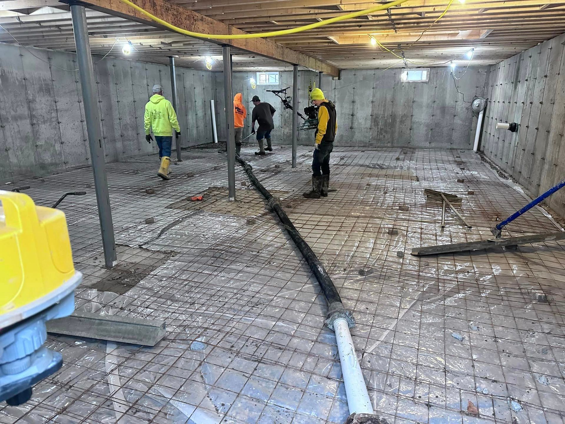 A group of construction workers are working in a basement.