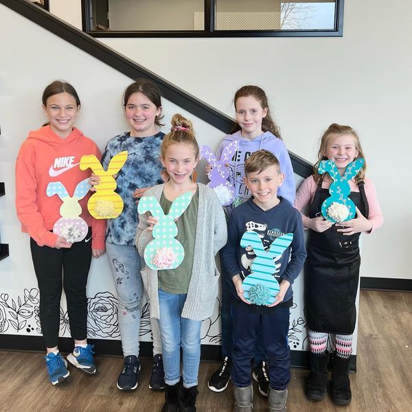 A group of children standing next to each other holding stuffed bunny rabbits