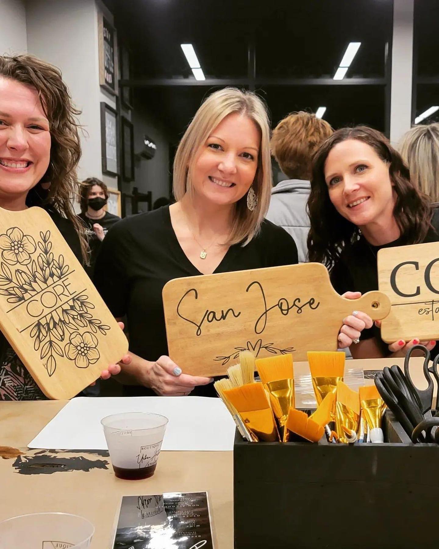 Three women are holding wooden signs that say san jose