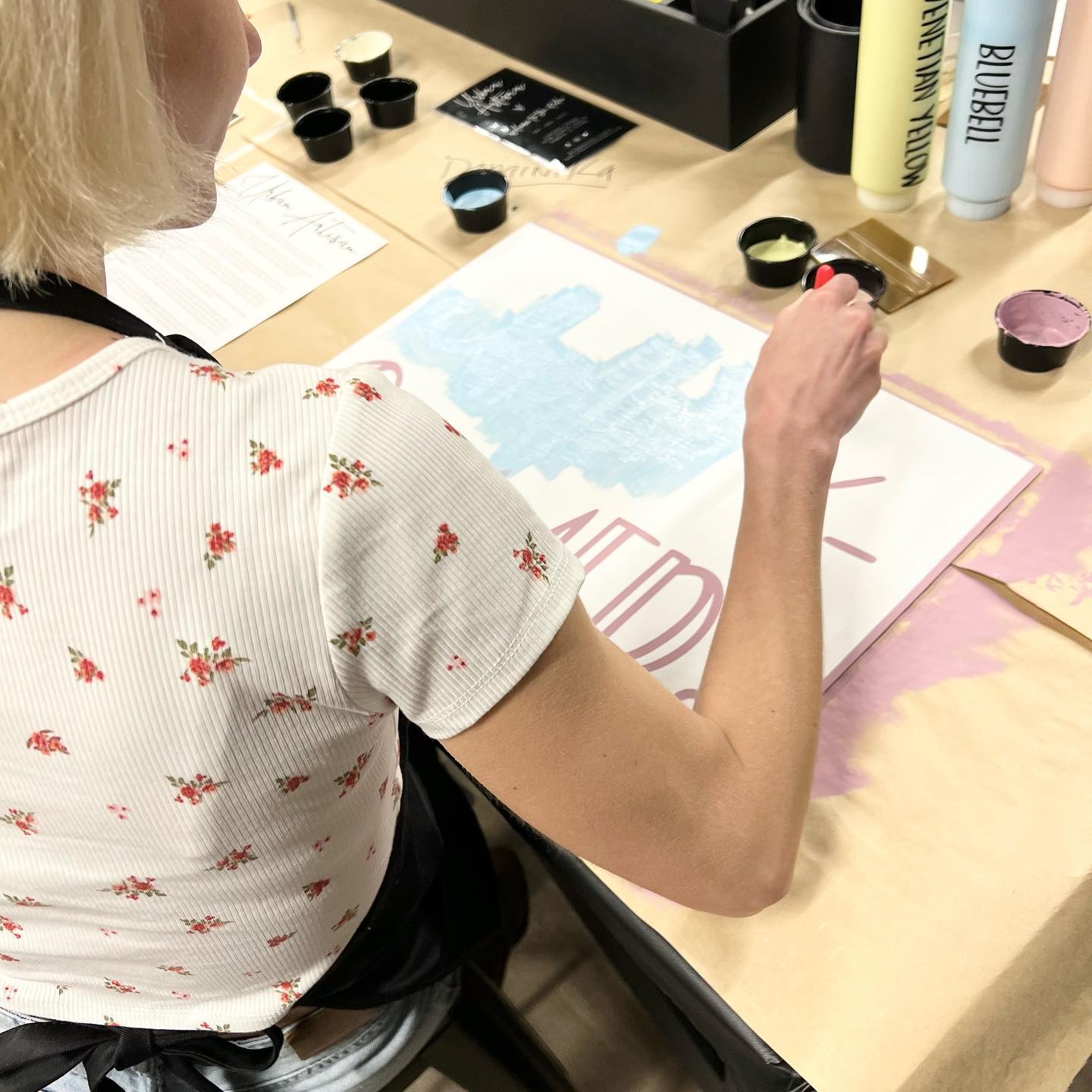 A woman sitting at a table with a bottle that says ' molly ' on it