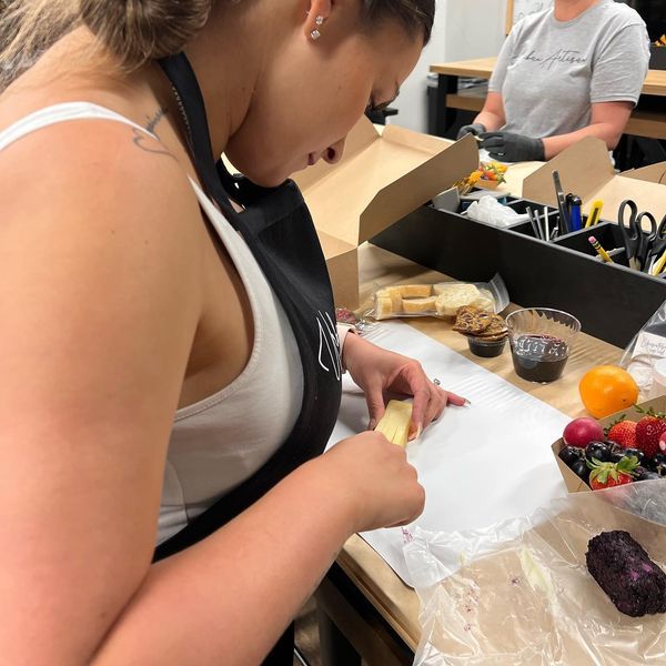 A woman in an apron is cutting a banana