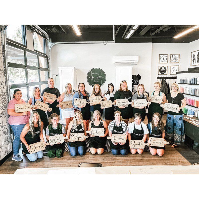 A group of women are holding wooden signs in a room.