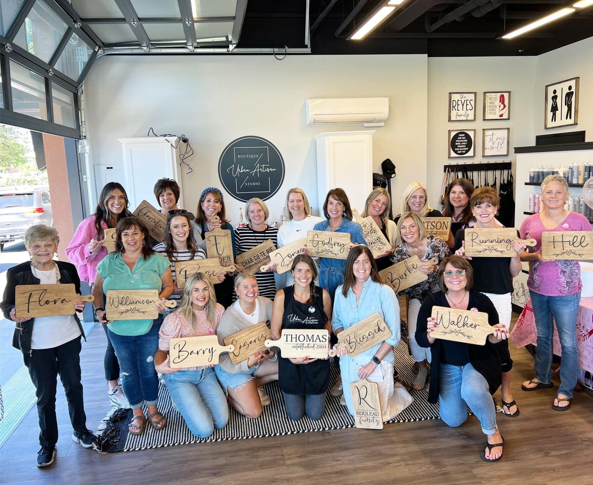 A group of women are posing for a picture in a room holding signs.