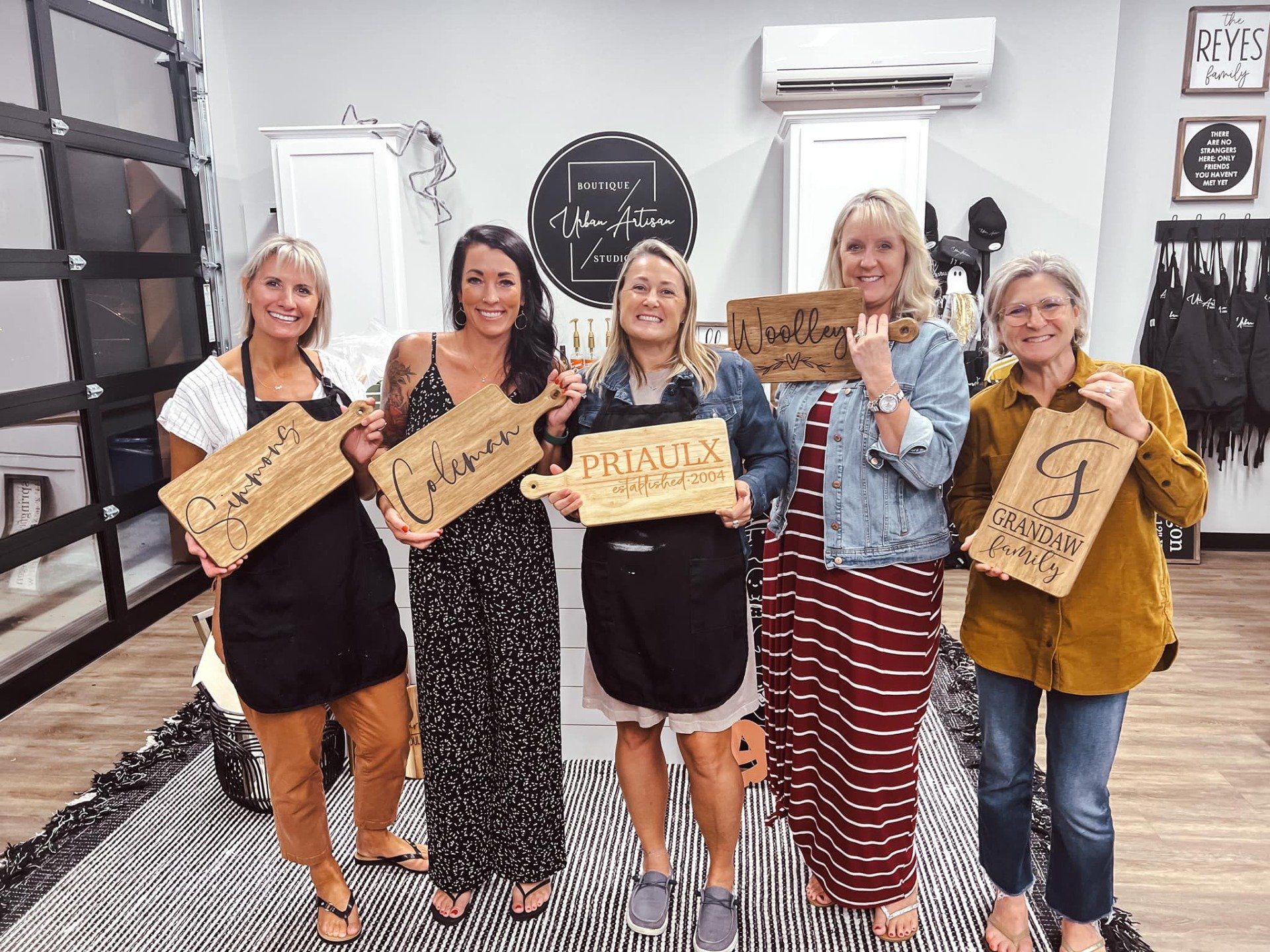 A group of women are standing next to each other holding wooden signs.