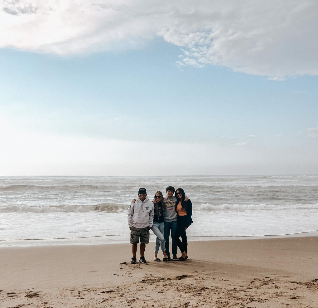 A group of people are posing for a picture on the beach.