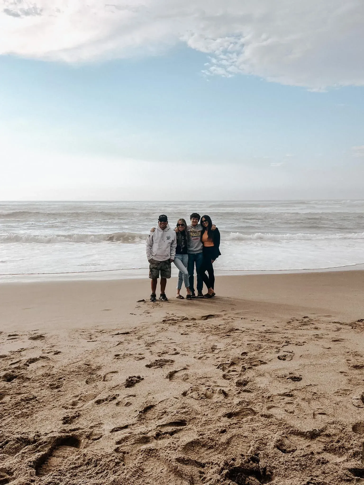 A group of people are posing for a picture on the beach.