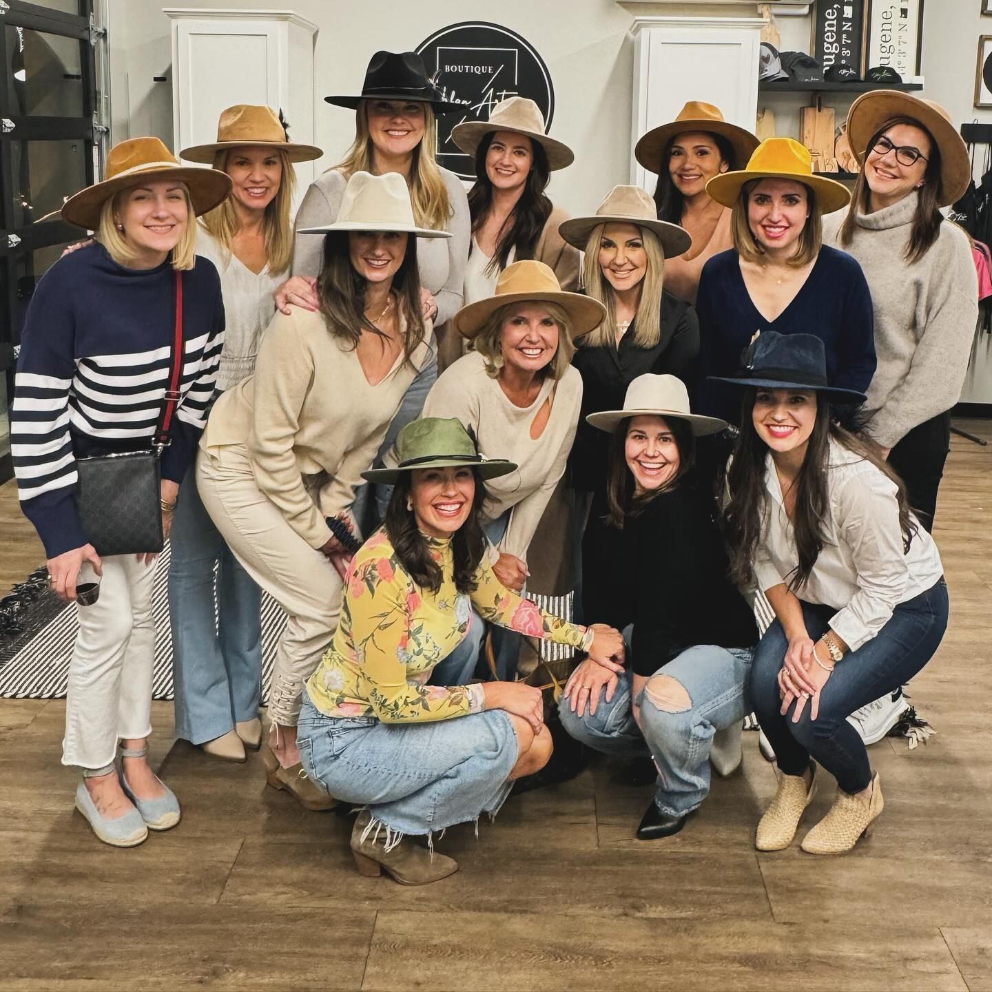 A group of women wearing hats are posing for a picture.