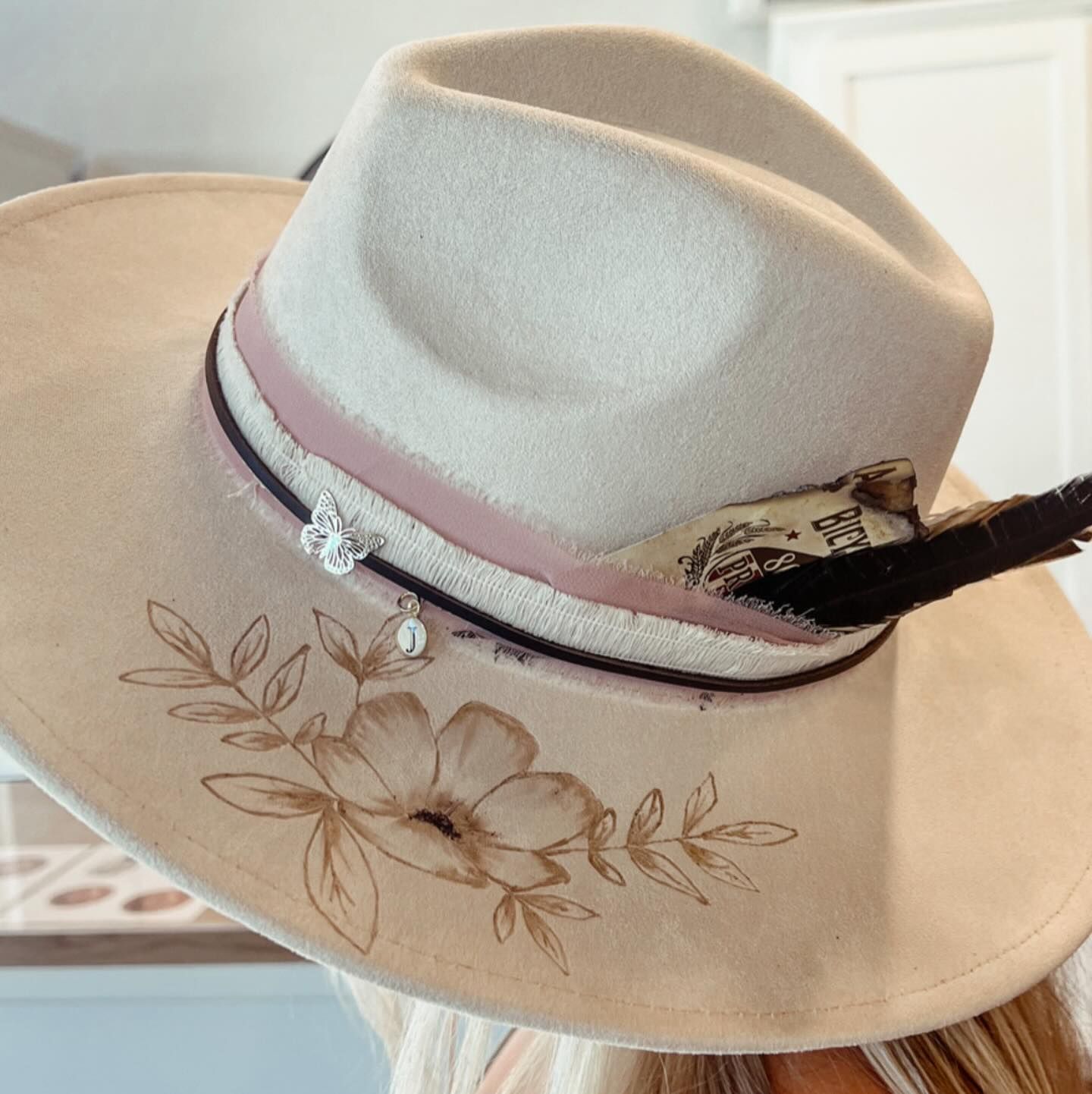 A woman wearing a hat with a feather and flowers on it