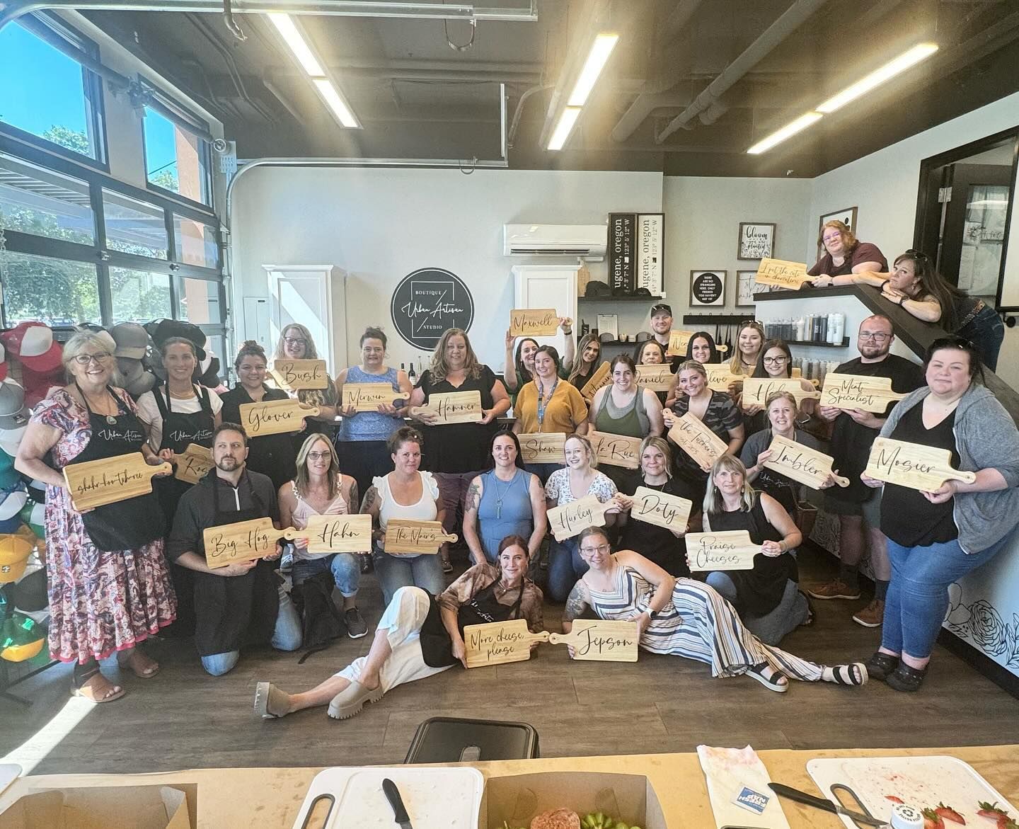 A group of people are posing for a picture in a room holding wooden signs.
