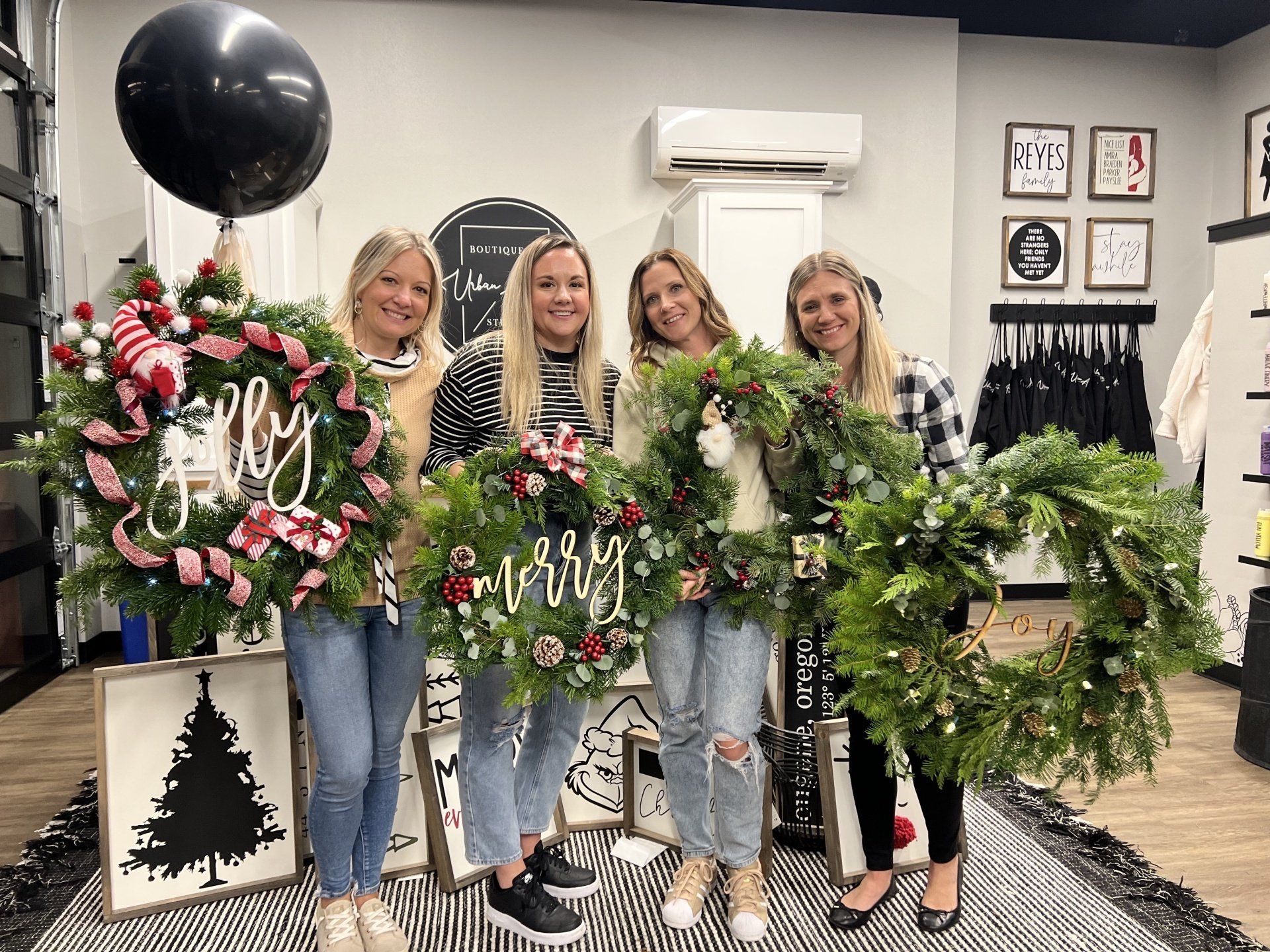 A group of women are holding christmas wreaths in a room.