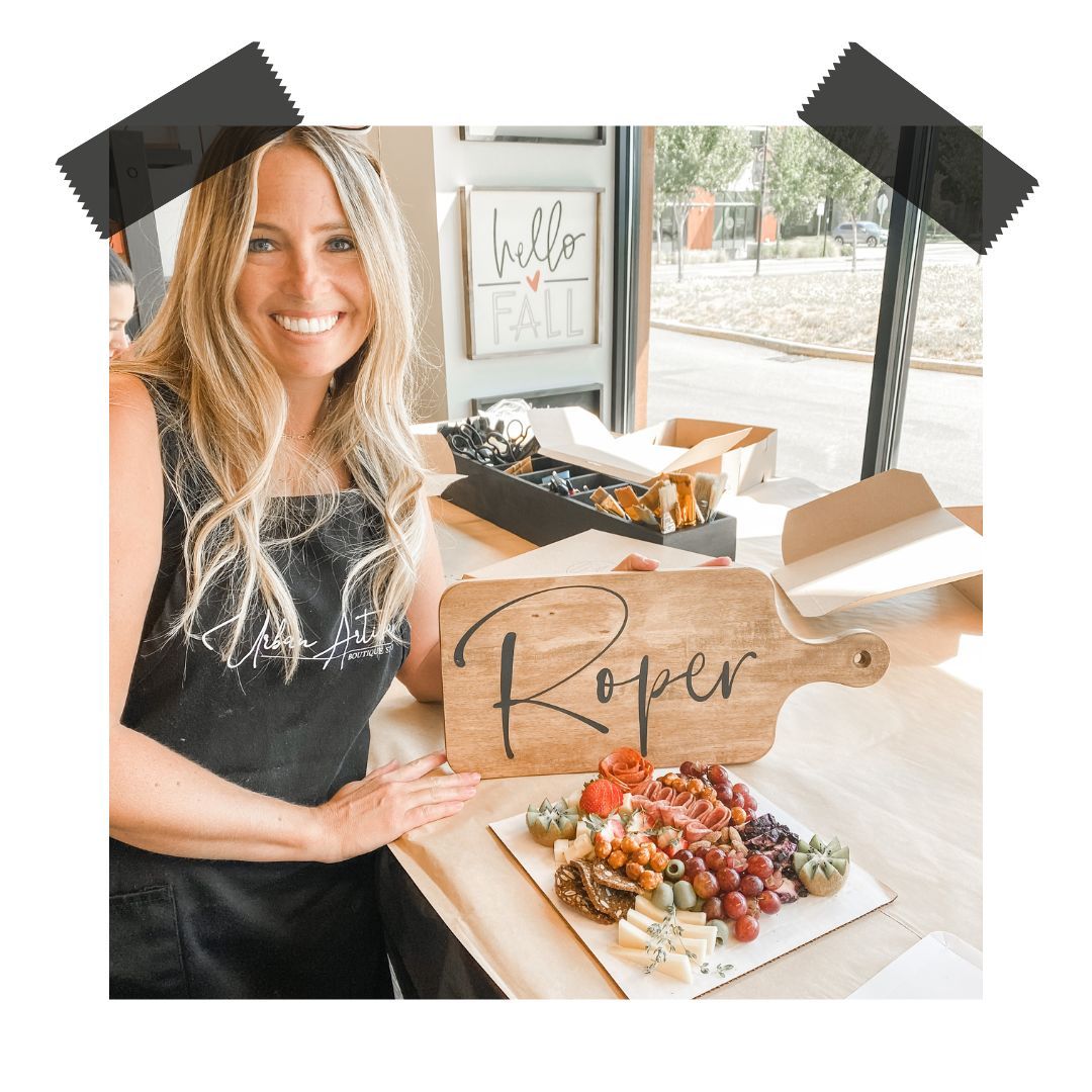 A woman is standing next to a wooden cutting board with the word roper on it.