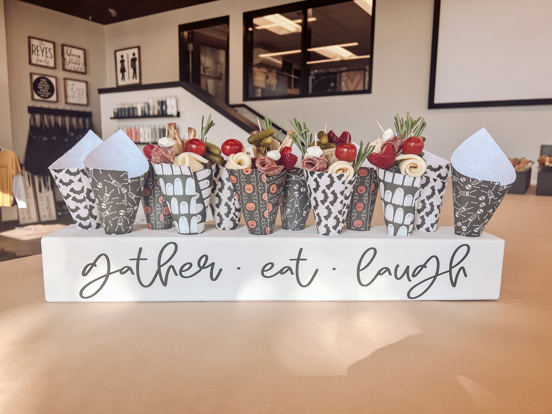 A sign that says gather eat laugh is sitting on a table.
