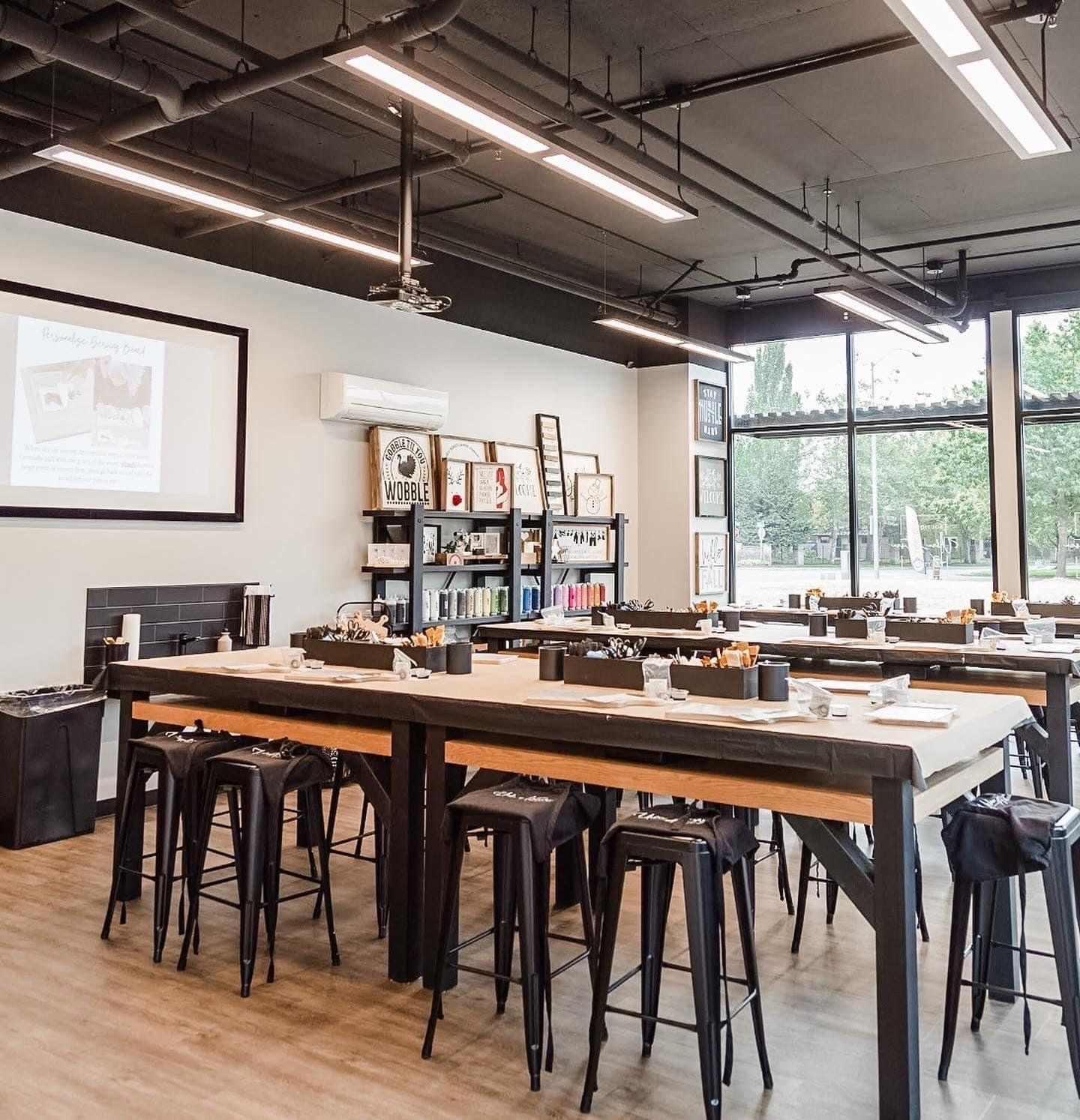 A large room with tables and stools in it