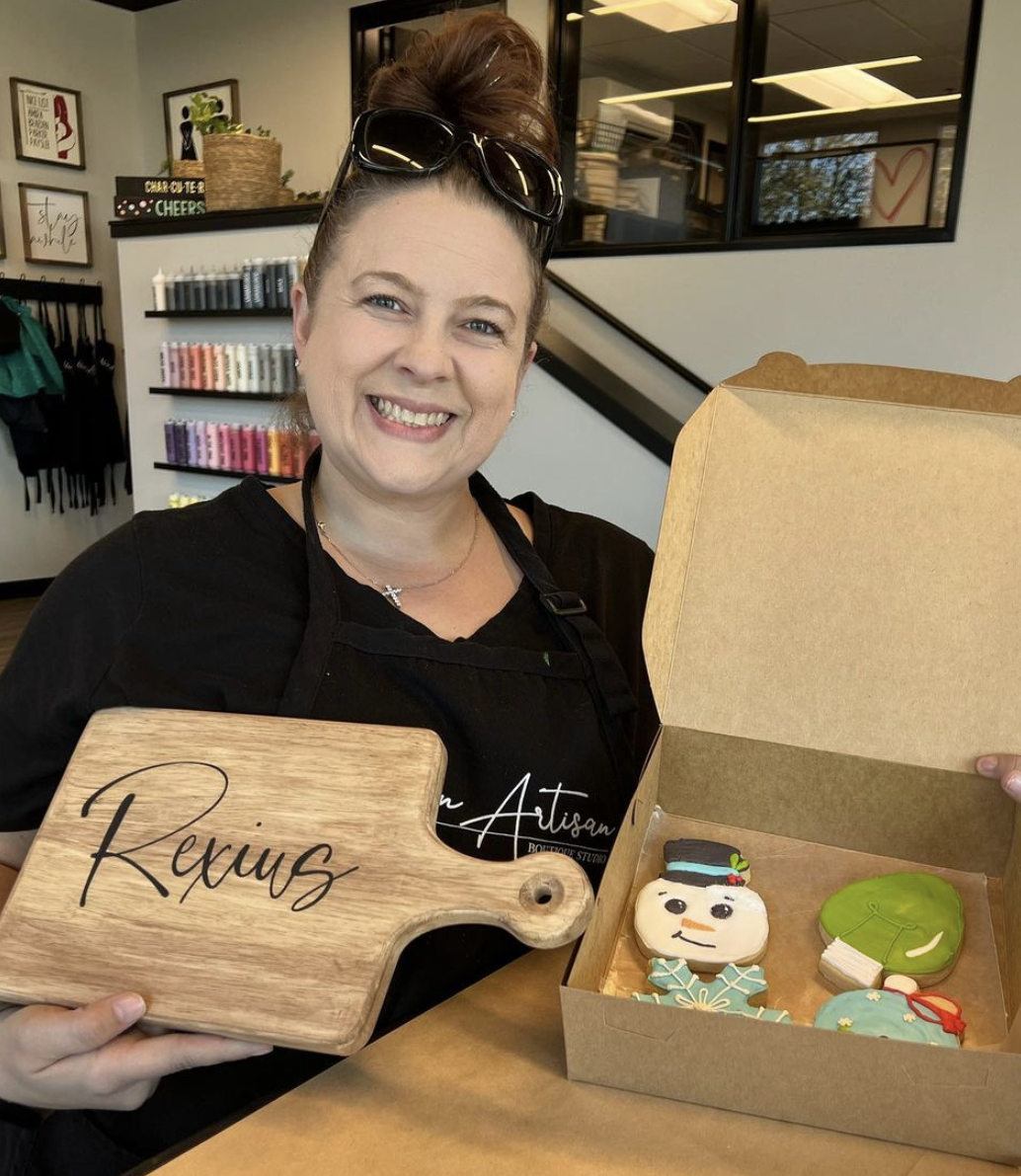 A woman is holding a cutting board that says rexus