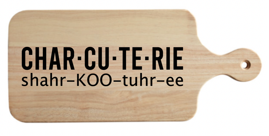 A wooden cutting board with the words char-cu-te-rie written on it