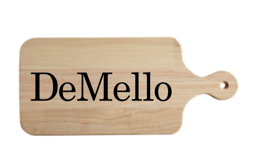 A wooden cutting board with the name demello written on it