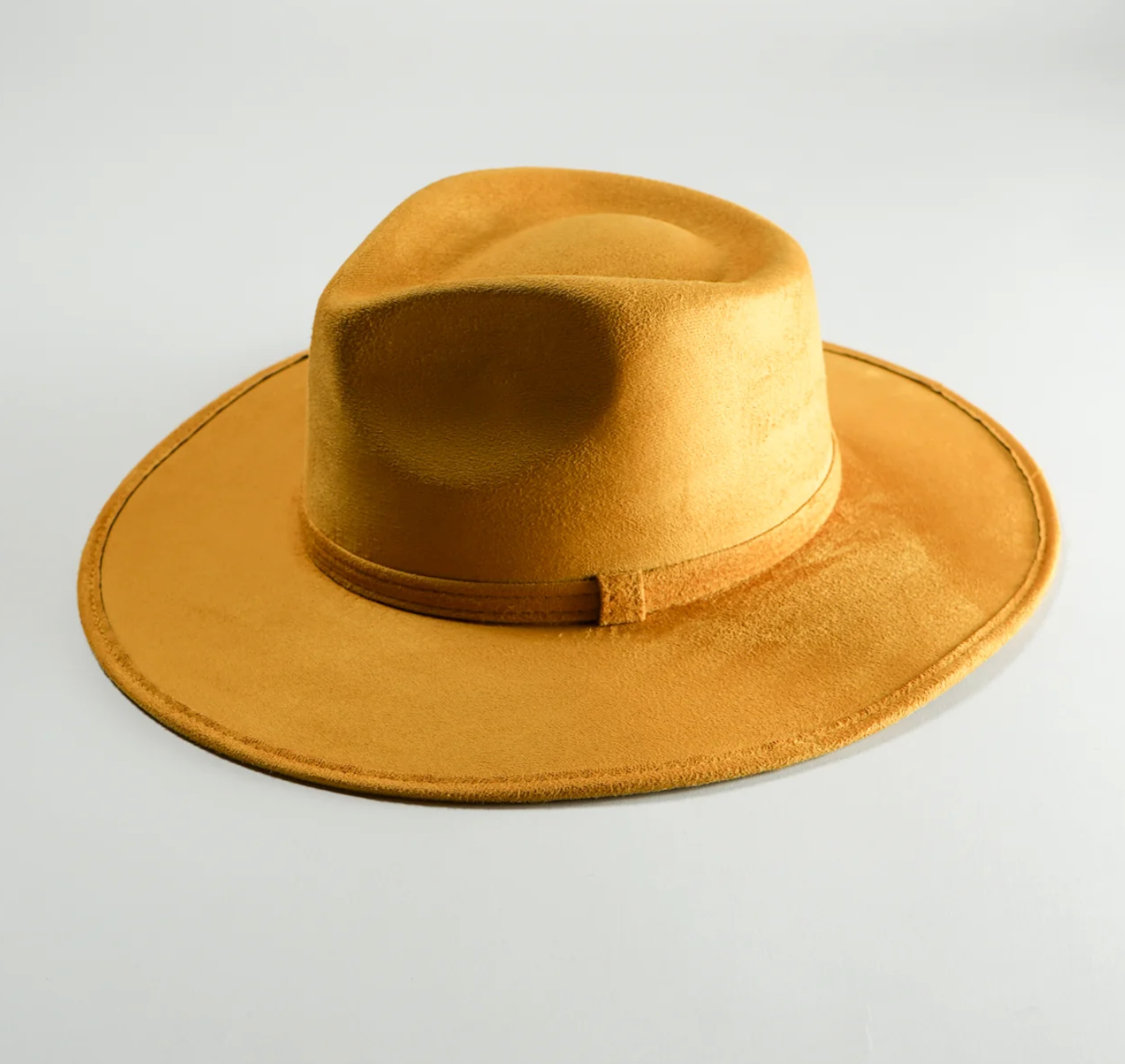 A yellow hat is sitting on a white surface