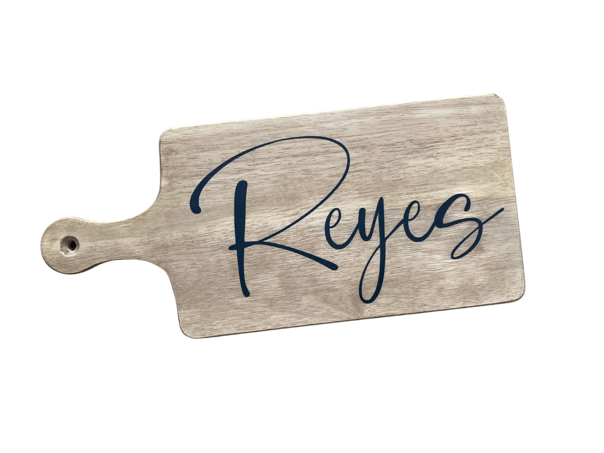 A wooden cutting board with the word reyes written on it.