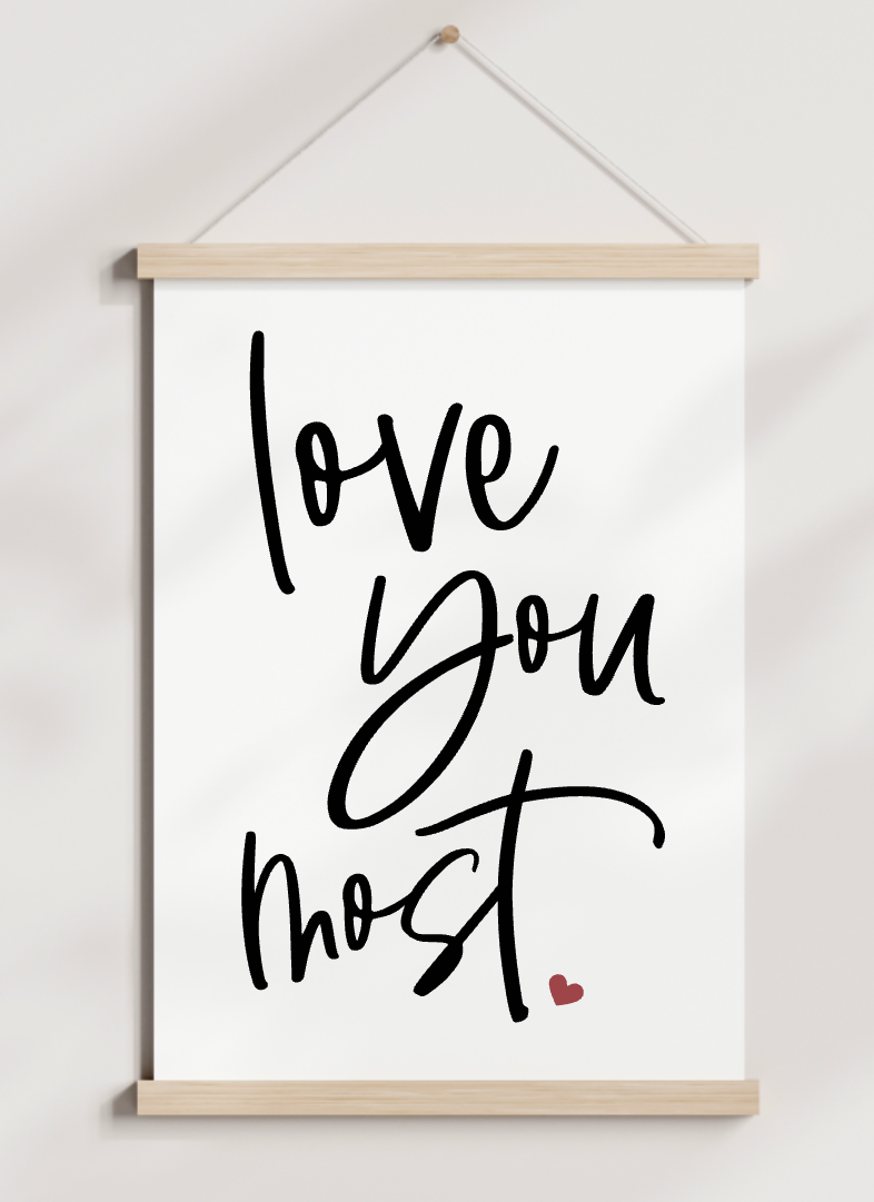 A poster hanging on a wall that says love you most