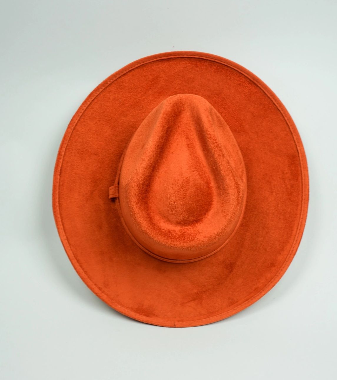 An orange hat is sitting on a white surface