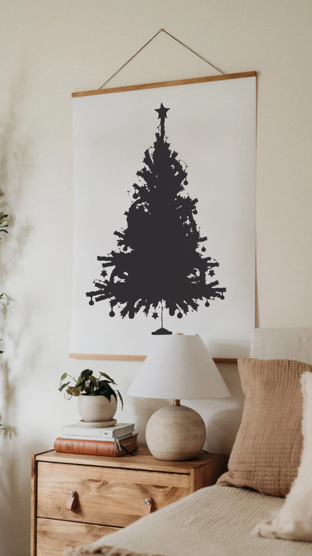 A silhouette of a christmas tree is hanging on a wall above a bed.